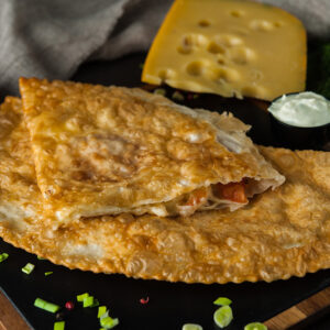 Cheburek with three cheeses and tomatoes
